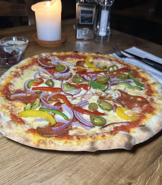Pizza Diavolo mit scharfer Salami, Mozzarella und Jalapenos, frisch gebacken im Trattoria Zollhof Düsseldorf Medienhafen.