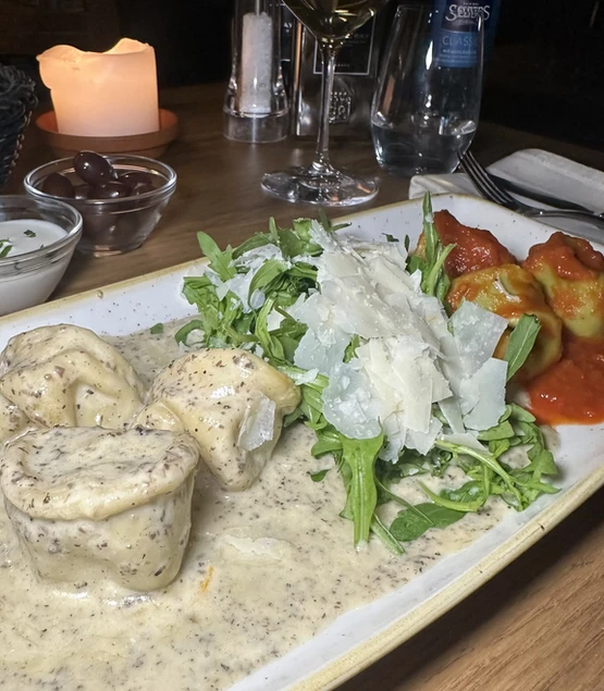 Duetto di Tortelloni, eine mit Steinpilzen gefüllte und auf Trüffelcreme servierte, die andere mit Ricotta und Spinat gefüllte auf Tomatensauce, im Trattoria Zollhof Düsseldorf Medienhafen.